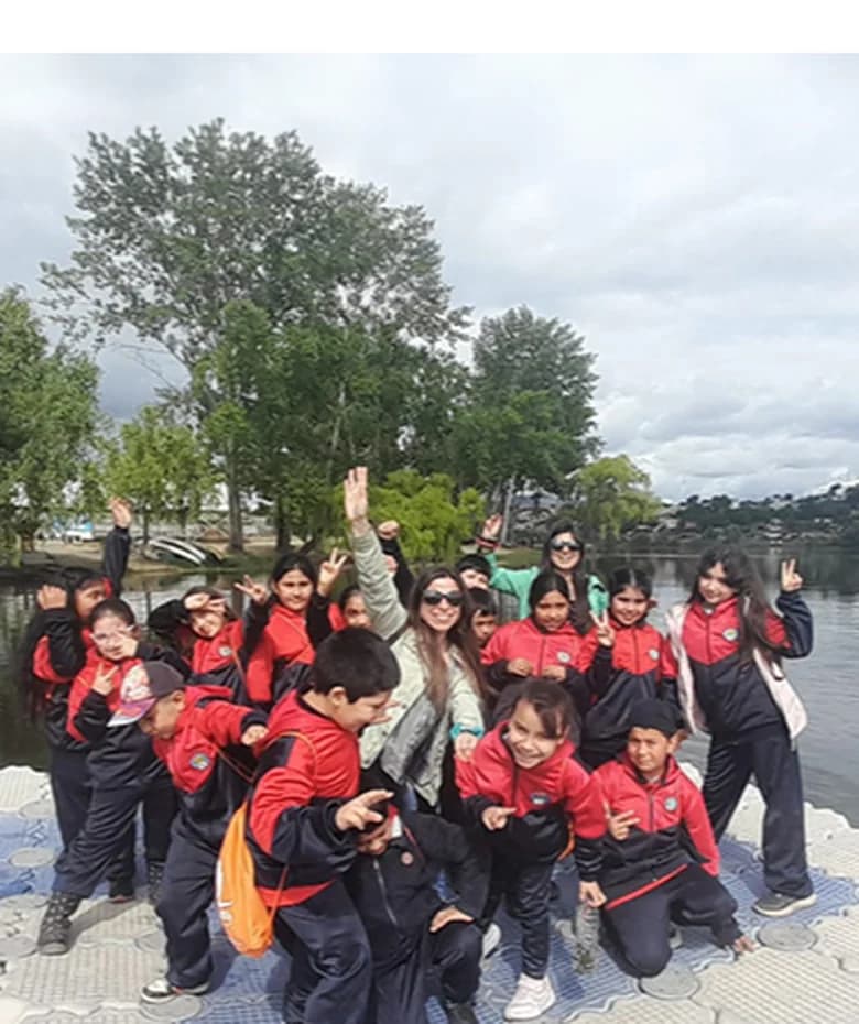 Estudiantes celebrando a orillas de una laguna durante una salida pedagógica